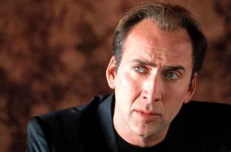 photo of nicolas cage, brown background, black shirt, shows from base of neck up