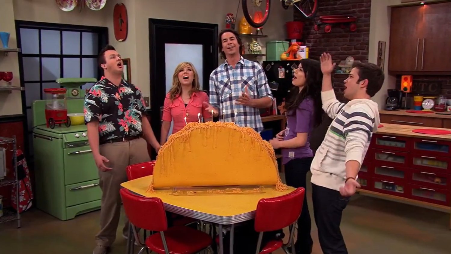 The iCarly cast huddled around a spaghetti taco