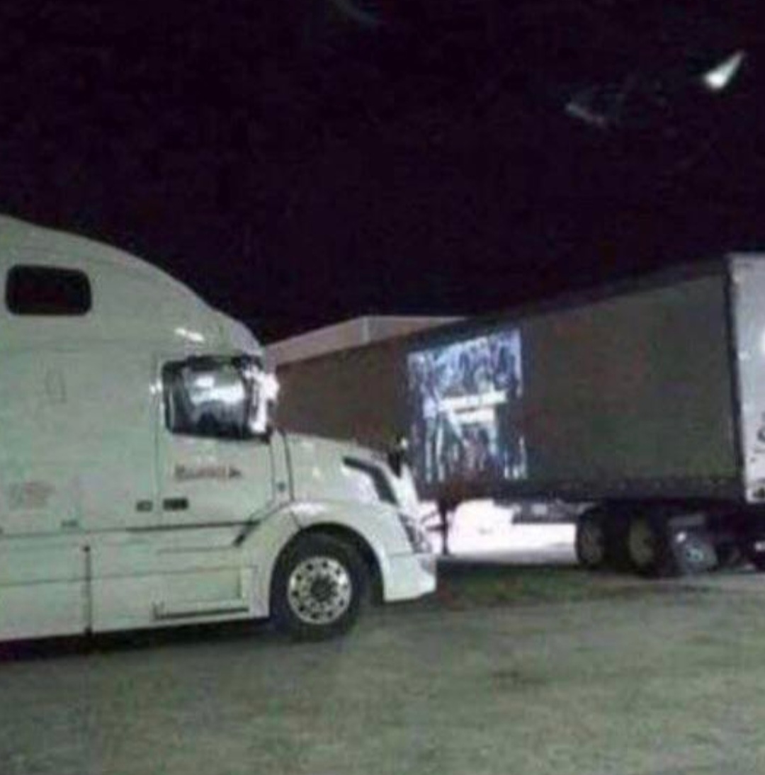 a truck driver watching a movie that is projected onto a trailer
